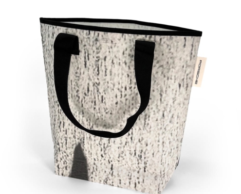 Unsere Einkaufstasche, Tasche X aus Grauen Mesh Banner mit schwarzen Elementen.
