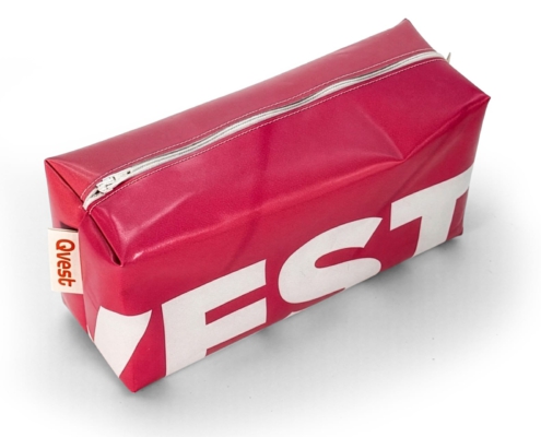 Detail einer roten Upcycling-Kulturtasche aus Werbebanner mit Qvest-Etikett und Reißverschluss