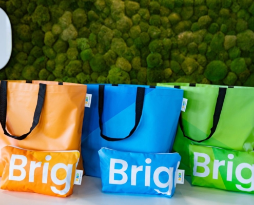 Orange, blaue und grüne Shopper und Kulturbeutel aus gebrauchten NXP-Messebannern
