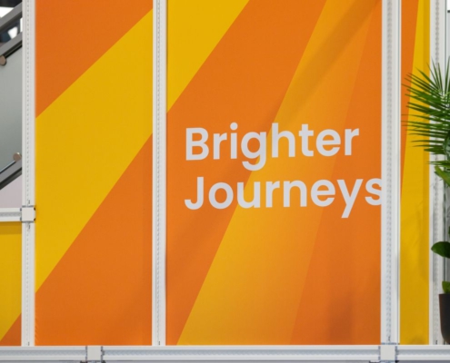 Orange-gelbes NXP-Messebanner mit dem Schriftzug „Brighter Journeys“
