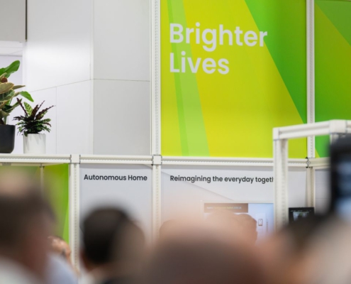 Grünes NXP-Messebanner mit dem Schriftzug „Brighter Lives“ am Messestand
