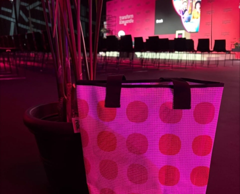 REAL EXPO_Messe_München_Banner wird zur Tasche_COMBAGS_00001 Upcycling-Einkaufstasche aus gepunktetem Mesh-Banner mit schwarzen Tragegurten und EXPO REAL-Label